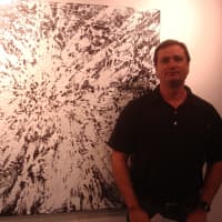 <p>Jeff Bortniker of Wesport with his painting &quot;Inflation&quot; at the Maritime Garage Gallery in Norwalk.</p>