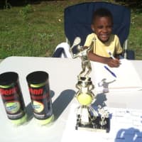 <p>Young Elijah Pitterson assists with running the tournament.</p>
