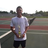 <p>A player holds up a trophy he won at a USTA Tournament in Norwalk.</p>