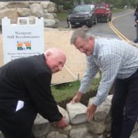 <p>Westport First Selectman Jim Marpe and Sam Gault of Gault Energy and Stone lay the capstones of the fieldstone wall around the Minute Man Monument.</p>