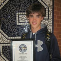 <p>Staples sophomore Luke Foreman shows off the certificate he received from the Guinness Book of World Records. The certificate confirms that Staples holds the record for most twins in an academic year. </p>