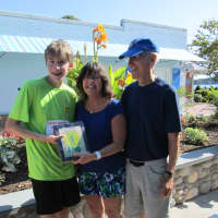 <p>The youngest runner in the 16th annual Ian James Eaccarino Memorial Nine-Mile Race, Jonathan Tinker, receives an award from Ginger and Larry Katz.</p>