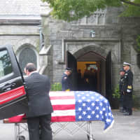 <p>The American flag-draped casket of former Congressman Peter A. Peyser outside of the Church of St. Barnabas before his burial at Sleepy Hollow Cemetery on Monday.</p>