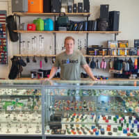 <p>Stoked Owner Charlie Ronemus behind a display at his 4-month-old smoke shop.</p>