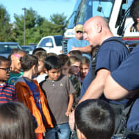 <p>Students speak to firefighters about fire safety, the fire truck, and the fire stack.</p>