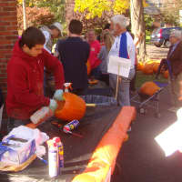 <p>Volunteers put the finishing touches on the jack-o-lanterns, spraying them with Clorox and WD-40 to prevent rotting and keep away animals.</p>