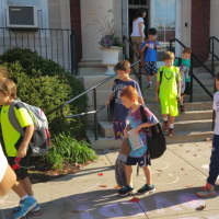 <p>Kids step across the color messages as they are dismissed from Kings Highway Elementary School in Westport on Friday. </p>