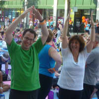 <p>Ian Rosenbluth (left), of White Plains, does his first sun salutation pose at the outdoor mega yoga event Wednesday in White Plains.</p>