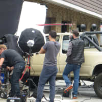 <p>The film crew hovers around the pickup truck.</p>