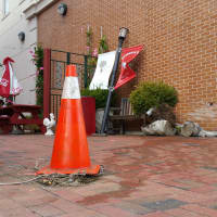 <p>An orange cone sits about 15 feet from the brick wall where the BMW X3 that struck Chief of Police Gary MacNamara&#x27;s unmarked police vehicle, made contact with a light post on the Firehouse Deli patio.</p>