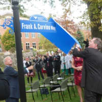 <p>Frank Corvino, president and CEO of Greenwich Hospital, at left, unveils the street sign for a section of Perryridge Road in front of the hospital named in his honor Tuesday. He will be retiring at the end of the year after 26 years at the hospital.</p>