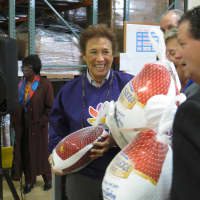 <p>Arlene Putterman, public &amp; community relations manager at Stop &amp; Shop, center, helps unload frozen turkeys for the holiday drive.</p>