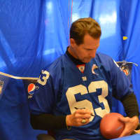 <p>Karl Nelson autographs a football as part of his appearance at the Stop &amp; Shop in Baldwin Place.</p>