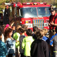 <p>A member of the Goldens Bridge Fire Department explains fire safety to children. </p>
