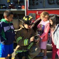 <p>A fireman teaches students about the fire hose. </p>