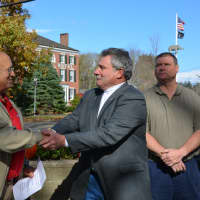 <p>Steven Delzio, left, and Arnold Guyot, right, shake hands at the dedication of an historic Somers water trough.</p>