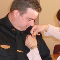 <p>Lisa Hartman pins the sergeant&#x27;s badge on to her husband David Hartman, who was officially promoted to sergeant in a ceremony Monday at the Wilton Town Hall Annex.</p>