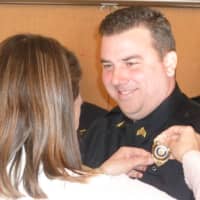 <p>Newly promoted Wilton Police Sergeant David Hartman, smiles at his wife Lisa as she pins his sergeant badge on during a ceremony at the Town Hall Annex Monday.</p>