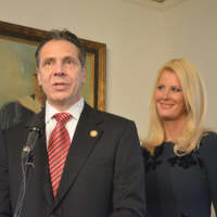 <p>Gov. Andrew Cuomo (left) addresses reporters after voting in New Castle, while Sandra Lee stands beside him.</p>