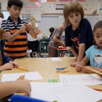 <p>Students from Ruth Sullivans third-grade class work alongside Patricia Zamperlins kindergartners on a science activity involving fall leaves.</p>
