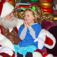 <p>A preschooler from the Boys &amp; Girls Club of Northern Westchester shares her Christmas wish list with Santa Claus at DreamWorks Animations North Pole Adventure.</p>