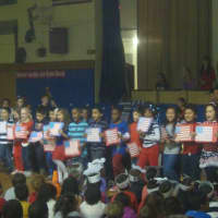 <p>Diana Guaglione&#x27;s second grade class performs &quot;You&#x27;re A Grand Old Flag&quot; for the whole school.</p>