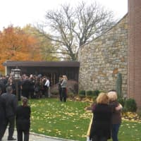 <p>Father Christopher Monturo hugged family members after the Mass of Christian Burial.</p>