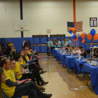 <p>Teammates sit at their tables for a Greeley Spelling Bee round.</p>