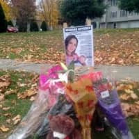 <p>A collection of flowers, along with a &quot;Reward Offered&quot; is set up near the intersection of South Street and Great Pasture Road, where Rachel Sack was killed last week by a hit-and-run driver. </p>
