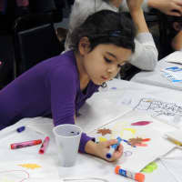 <p>Juliet Galeon, 3, of Scarsdale takes the art of decorating bags seriously.

</p>