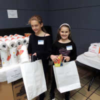 <p>Sydney Anmuth, 10, and Chloe Anmuth, 8, of Rye Brook fill bags with paper towels and tissues.</p>