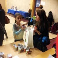 <p>Chloe Zacks and her mom, Felicia, of Armonk, pack a bag with cans of tuna and tomato sauce.</p>