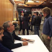 <p>Taylor Wacksman of Mamaroneck enjoys the chance to meet acclaimed sports writer Mike Lupica in Katonah Sunday at a meet and greet following a sports interview program at The Harvey School.</p>