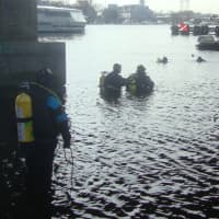 <p>Members of the Norwalk and Darien police scuba teams dive down to survey a submerged SUV and attach cables to pull it out.</p>