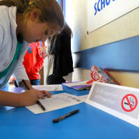 <p>A Briarcliff middle schooler signs a pledge to not use tobacco products for a year. </p>