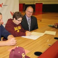 <p>Katie Feigenbaum signs her commitment letter as Eastchester Athletic Director Jason Karol and Superintendent of Schools Walter Moran look on.</p>