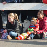 <p>A mild day allowed spectators to sit on the pavement during the parade.</p>