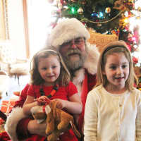 <p>Santa Claus, an LMMM Trustee and Stew Leonards Vice President Doug Hempstead, with two Santa fans in 2013.</p>