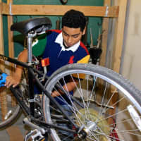 <p>A member of the club works on a bike. </p>