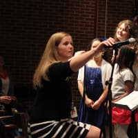 <p>Pocantico School Music Director Sheila DePaola adjusted the microphone for a singer.</p>