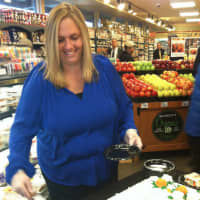 <p>Carol Donnoli, bakery field merchandiser for Balducci&#x27;s, cuts the cake during the market&#x27;s grand re-opening on Friday.</p>