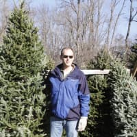 <p>Chappaqua First Congregational Church member Rib Jakacki picks out a tree with his family as he stands next to a possible option.</p>