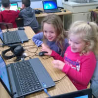 <p>First-grade students take on a game involving coding.</p>
