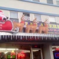 <p>An inflatable Santa and reindeer are flying across the sign at the Las Americas restaurant on Main Street in Danbury. </p>