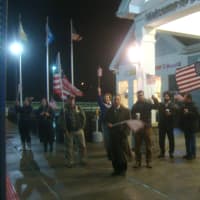 <p>Supporters of Wreaths Across America wave American flags in greeting to the caravan of trucks as it pulls into the service plaza.</p>