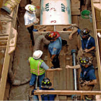 <p>Before drilling, members of the Stamford Fire Department are briefed by a project contractor on the tunneling operation under the Metro-North Railroad right of way near Lincoln Avenue.</p>