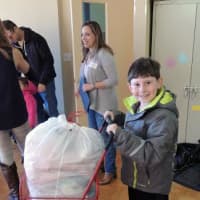 <p>Noah Geller, 9, of Harrison carts clothes for donation to WJCS Kids Kloset.</p>