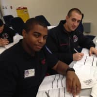 <p>Probationary firefighters Donavan McKenzie and Joseph Santobello filling out the necessary paperwork.
</p>