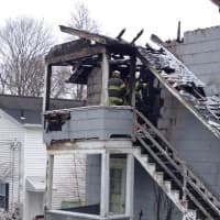 <p>Fire officials climb the stairs of a Danbury home that caught fire overnight. </p>