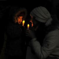 <p>Candles are distributed among attendees.</p>